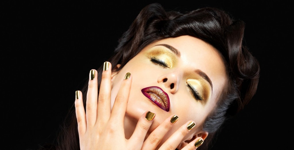 Beautiful woman with golden nails and style makeup